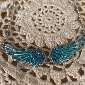Blue rhinestones on silver tone angel wings, necklace. Preowned.